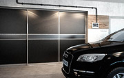 Szafa wnękowa w garażu czarno-szara i Audi Q7